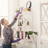 A woman dusting a shelf to improve indoor air quality in her home: A woman dusting a shelf to improve indoor air quality in her home